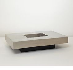 a square metal object sitting on top of a white table