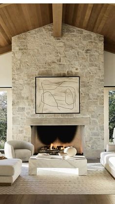 a living room filled with furniture and a fire place in front of a stone fireplace