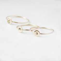 One gold letter ring. Personalize a gift she'll treasure with our gold initial ring. An adorably petite initial, imprinted on a 14k gold filled disk - paired with a super skinny (1mm) gold filled band - creates the perfect stacking ring, customized with your monogram. Lovely as a stand alone. Also sits beautifully with multiple initials stacked or our hammered gold stacking ring bands. This gold initial ring arrives custom made to order in your size hand stamped with the letter of your choice. A Gold Stackable Rings With Initials For Everyday, Everyday Gold Stackable Rings With Initials, Gold Sterling Silver Initial Stackable Ring, Gold Sterling Silver Stackable Initial Ring, Gold Sterling Silver Stackable Rings With Initials, Simple Stackable Initial Ring, Minimalist 14k Gold Monogram Rings, Dainty Gold Stackable Rings With Initials, 14k Gold Stackable Rings With Initials