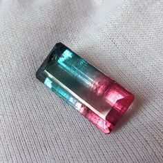 two different colored stones sitting on top of a white blanket