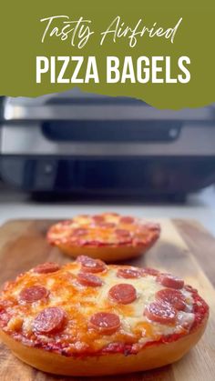 two pepperoni pizzas sitting on top of a wooden cutting board next to an air fryer