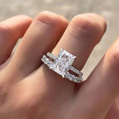 a woman's hand with a diamond ring on top of her finger and the engagement band