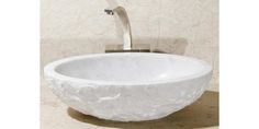 a white bowl sink sitting on top of a marble counter next to a faucet