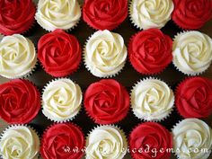 cupcakes decorated with red and white frosting are arranged in rows on a table