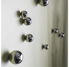 several chrome knobs on a white wall