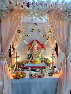 an idol is displayed on a table with flowers and other items around it for consumption