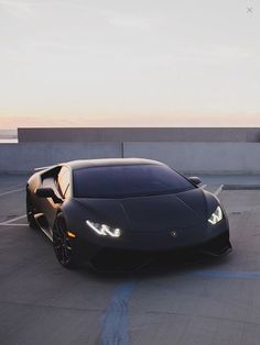 a black sports car driving down a road