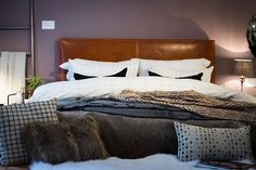 a large bed with pillows and blankets on it's headboard in a bedroom