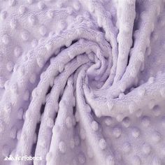 a close up view of a purple blanket with white dots on the top and bottom