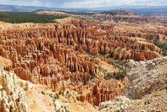 the canyon is filled with many different types of rock formations and trees in the distance