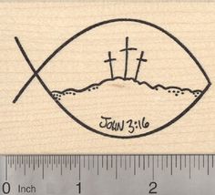 a wooden stamp with the words jesus and two crosses on it, in front of a ruler