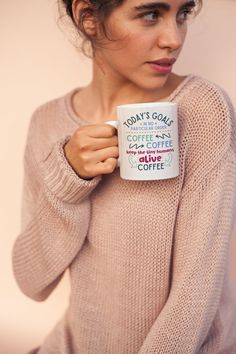 a woman is holding a coffee mug in her hands