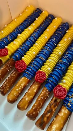 an assortment of colorful candy sticks with flowers on them in a box, ready to be eaten