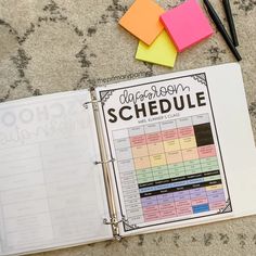 a binder that is sitting on the floor next to some pens and sticky notes