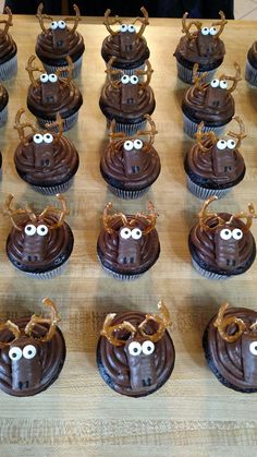 chocolate cupcakes decorated with googly eyes and spider webs are on a wooden table