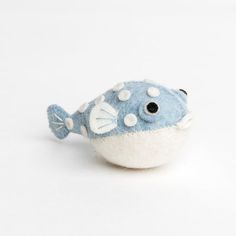 a blue and white stuffed fish on a white background