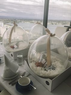 two glass balls with writing on them are sitting on a table next to a cup and saucer