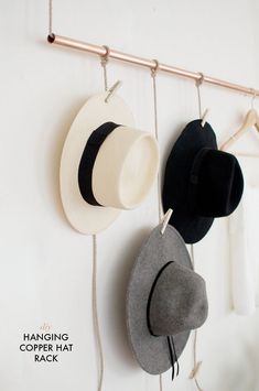 hats are hanging on the wall next to a coat rack with hooks and clothes pins