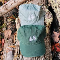 Our White Pine and Spruce Washed Chino Hat is the perfect adventure and hiking hat. Depicting two of Maine’s most iconic trees, this tree hat is perfect for any forest lover. Made for men and women. Dad Cap: 100% cotton garment-washed twill - adjustable tri-glide buckle closure Trucker Cap: Pigment Dyed - 55/45 cotton/polyester, mesh with snap back closure Embroidered Locally Unstructured, six-panel, low-profile Green Cotton Trucker Hat For Outdoor, Cotton Baseball Cap For Hiking, Cotton Camping Hat, One Size Fits Most, Cotton Curved Brim Baseball Cap For Camping, Cotton Baseball Cap With Curved Brim For Camping, Cotton Baseball Cap For Camping With Curved Brim, Curved Brim Cotton Hat For Hiking, Cotton Hiking Hat With Curved Brim, Outdoor Cotton Hat One Size