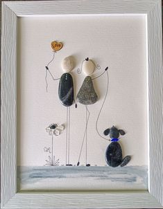 an art work with rocks and flowers on the ground, including two dogs holding balloons