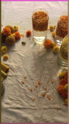 three glass vases filled with flowers sitting on top of a white tablecloth covered table