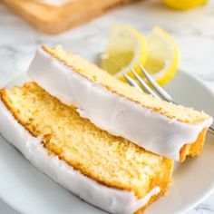 two slices of lemon pound cake on a white plate with a fork next to it