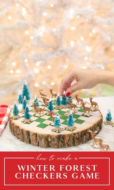 a person is decorating a wooden chess board with christmas trees on it and the words winter forest checkers game