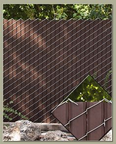 an arrow sign in front of a fence with trees and bushes behind it on the other side