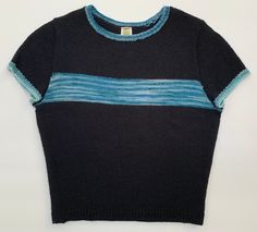 "Handknit in Massachusetts, this everyday tee is bold yet soft. Mostly black, though colors in the contrast yarn - blue, white, and teal, are showcased in the retro stripe across the bust. Slightly cropped, this tee is perfect on its own or layered under a jacket. See measurements and yarn contents below. Tee measurements: Underarm to underarm, flat: 17\" Underarm to hem: 11\" Hem, flat: 13.5\" Fiber content: Main color: 100% Wool Contrast color: 75% Wool - Merino, 25% Manufactured Fibers - Nylo Navy Knit Short Sleeve Tops, Blue Cotton Short Sleeve Knit Top, Blue Short Sleeve Cotton Knit Top, Blue Cotton Knit Top With Short Sleeves, Black Knit Crew Neck Top, Navy Knit Tops For Layering, Casual Blue Knit T-shirt, Blue Knit Tops For Layering, Blue Knit Short Sleeve Top