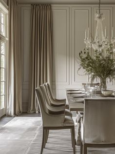 an elegant dining room with chandelier and table set for four, in neutral tones