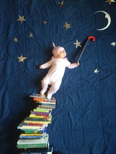 a baby laying on top of a pile of books