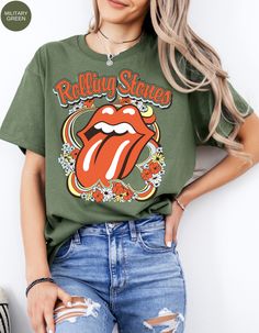 Step back in time and rock out in style with our Vintage Flower Rolling Stone Tee! 🌸🎸 This retro-inspired t-shirt features a classic Rolling Stone logo beautifully intertwined with vibrant flowers, capturing the free-spirited essence of rock 'n' roll and the timeless charm of the 70s. 🌼✨ Crafted from super-soft, high-quality fabric, this tee offers ultimate comfort and a perfect fit, making it an essential addition to your wardrobe. Whether you're heading to a concert, a festival, or just channeling your inner rock star, this tee will have you looking effortlessly cool and totally groovy. 🌟👕 Get ready to roll and bloom with style! 🌿🎶🛒 Retro Green Printed T-shirt, Retro Relaxed Fit T-shirt For Music Festival, Green Summer Concert Tops, Green Summer Concert Top, Green Summer Top For Concerts, Retro Graphic Print T-shirt For Spring, Spring Music Festival Crew Neck Tops, Spring Hippie Retro Print T-shirt, Crew Neck Tops For Spring Music Festival