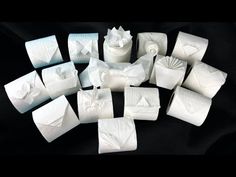 several pieces of white tissue sitting next to each other on a black surface with paper folded around them