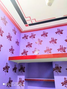 a purple room with red flowers on the wall and ceiling painted in bright pinks