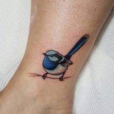 a small blue bird with a baseball bat tattoo on the ankle, by an artist