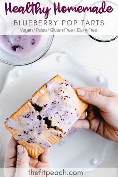 two hands holding a blueberry pop tarts on a plate