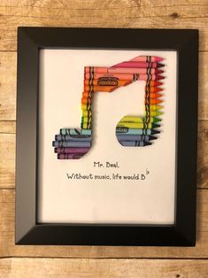 a framed art piece with colored crayons in the shape of a musical note