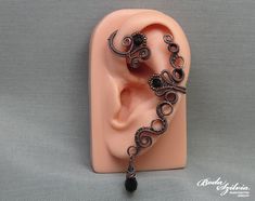 Wire wrapped gothic ear wrap with black crystals, no piercing required. It's made of copper wire, seed beads and black crystals. Antiqued and carefully polished. Available: - left ear - right ear - pair Plz, select from the list (select style). Made for order. I'll need 1-5 days to make your ear cuff. Please note that each piece is made 100% by hand and may vary a little from the photo. You can find more ear wraps here: https://www.etsy.com/shop/bodaszilvia?section_id=10953132&ref=shopsection_le Handmade Black Ear Cuff, Handmade Adjustable Black Ear Cuff, Unique Black Ear Cuff Single Piece, Handmade Black Ear Cuff Gift, Handmade Black Ear Cuff As Gift, Handmade Black Ear Cuff For Gift, Unique Black Single Ear Cuff, Handmade Black Bohemian Body Jewelry, Ear Wraps