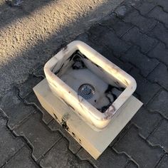 an old broken sink sitting on the ground