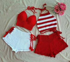 three pieces of red and white crocheted swimsuits on a bed next to a pink flower