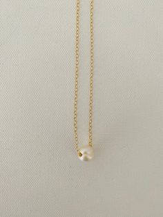 Just A Pearl! This simple yet elegant necklace is part of my Just A Pearl collection. One single pearl dangles from a delicate gold necklace. It measures 16 inches and length and can be adjusted to 15 inches for choker length. Minimalist Pearl Chain Necklace With Pearl Charm, Classic Gold Charm Necklace With Pearl Drop, Simple Gold Jewelry With Pearl Pendant, Classic Pearl Charm Necklace With Pearl Chain, Minimalist Pearl White Chain Necklace With Pearl Drop, Minimalist Pearl Drop Necklace With Pearl Chain, Minimalist Pearl Drop Chain Necklace In Pearl White, Classic Pearl Necklace With Round Pendant And Delicate Chain, Simple Necklace With Pearl Chain For Gift