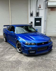 a blue car parked in front of a garage