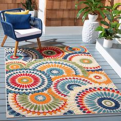 a colorful area rug on a deck with a chair and potted plant in the background