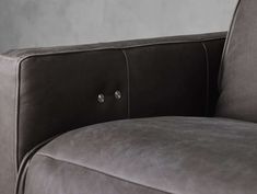 the back end of a couch with buttons on it's arm and side panel