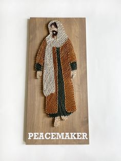 a piece of artwork with the words peacemaker on it and an image of a man in a coat