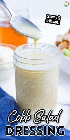 a spoon pouring dressing into a jar with the words cob salad dressing on it