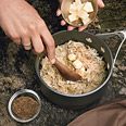 a person scooping food out of a pot