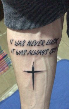 a person with a cross tattoo on their leg that says it was never lucky it was always god