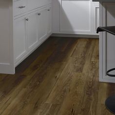 a kitchen with wooden floors and white cabinets