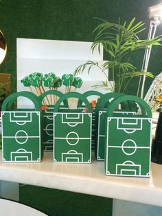 green bags with white lines on them sitting on a table in front of a lamp